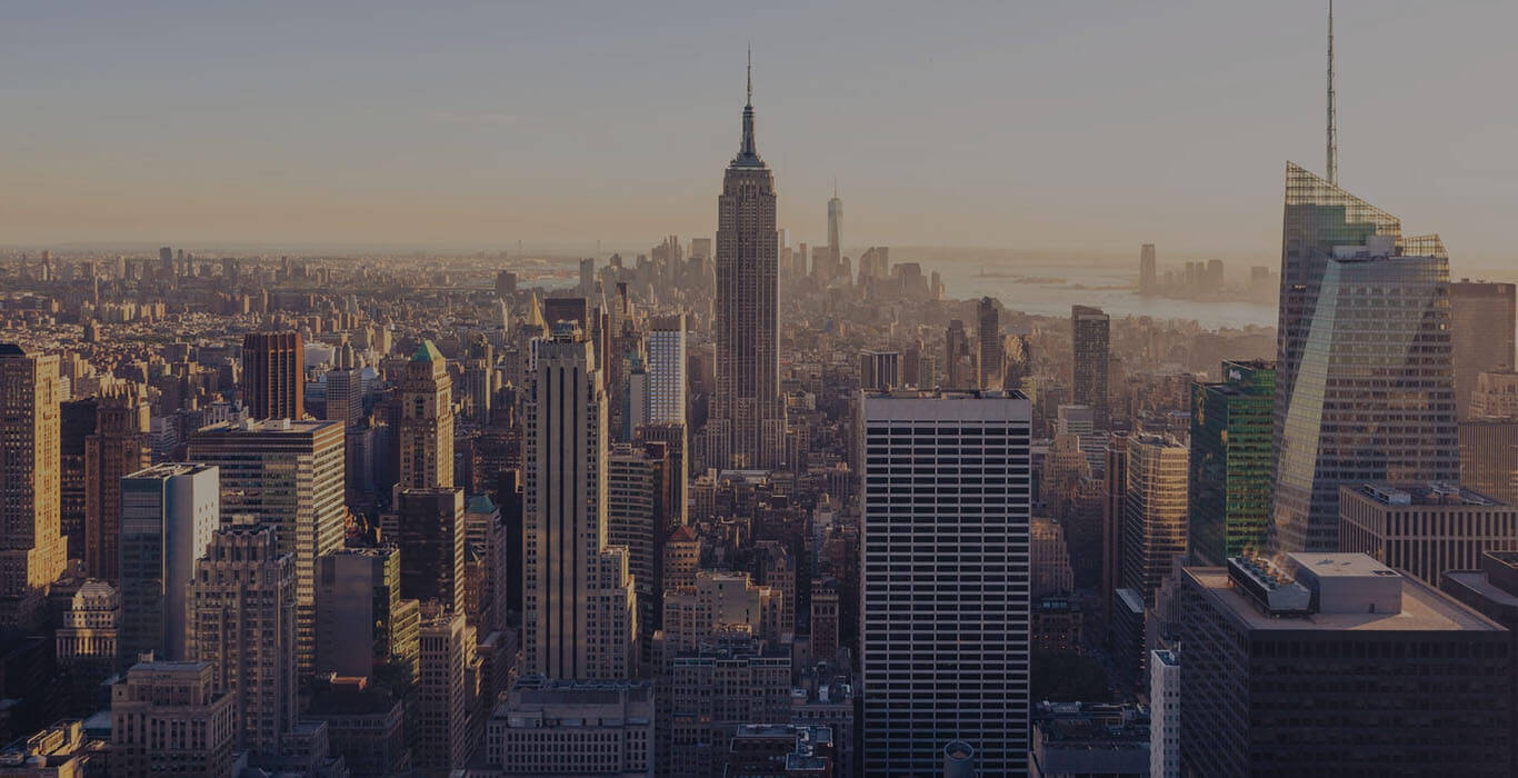 A metropolitan skyline bathed in warm golden light at sunset.